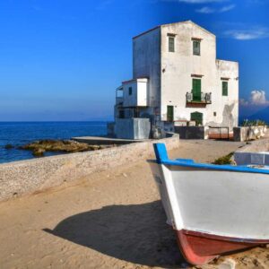 "sant elia frazione comune di santa flavia vista spiaggia della casa bianca con barca in primo piano cielo azzurro"