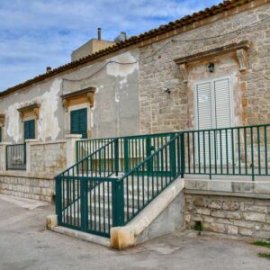 "abitazione lungomare con ringhiere metallo verde"