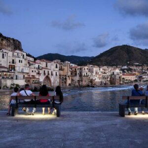 "persone su panchine al tramonto cefalù"