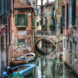 "ponte sul canal san boldo con barche e case antiche di mattoni"