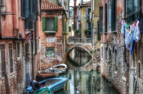 "ponte sul canal san boldo con barche e case antiche di mattoni"