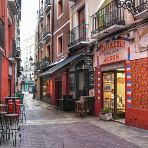 "via con bar il primo con tavolini rosso"