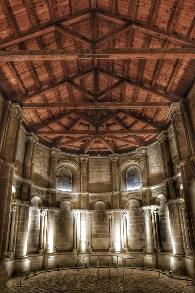"splendida sala illuminazione soffusa tetto in trani legtno con serie di colonne a semiarchi con capitelli"