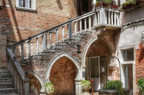 "piccola corte privata con scale del seicento in marmo una vera da pozzo e ingresso con tettoia"