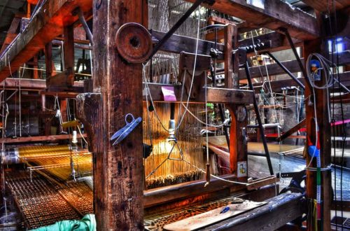 "macchinario antico per tessitura con utensili con luce soffusa suggestiva"