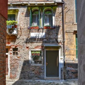 "piccola corte con porta e poggiolo fiorito"