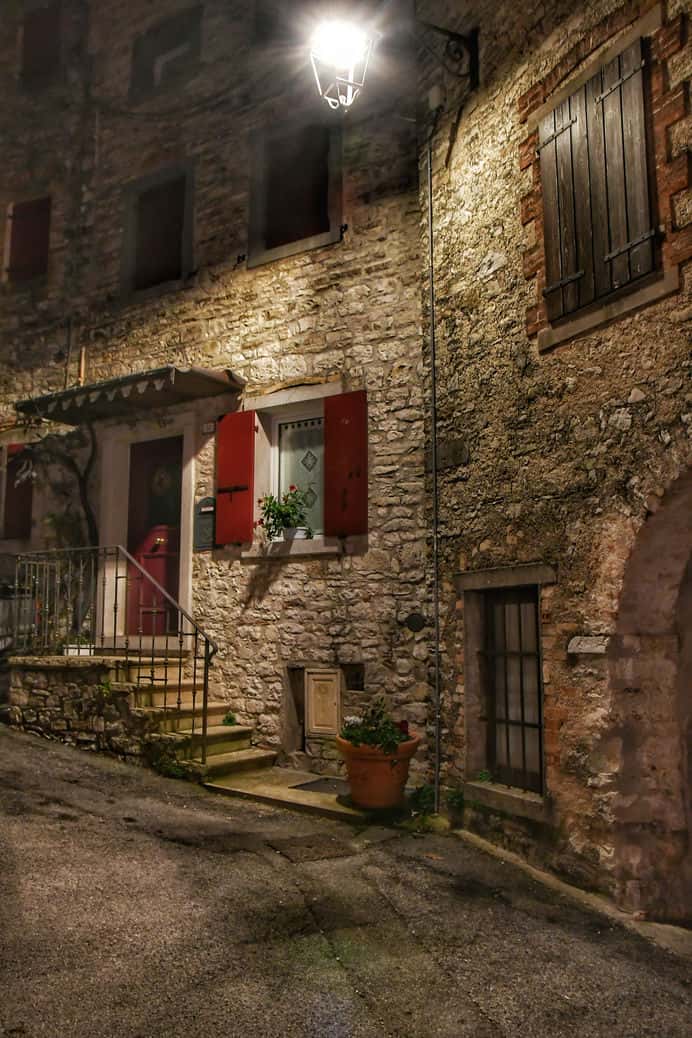 "combai di notte casa in pietra con piccola scalinata e infissi marroni"