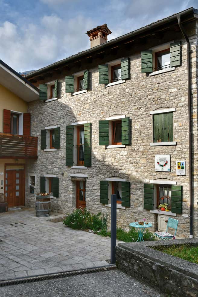 "agriturismo storico tre piani infissi verdi struttura pietre"