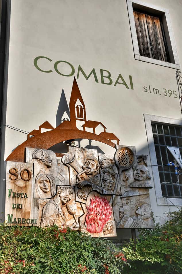 "scritta combai con opera artistica in legno"